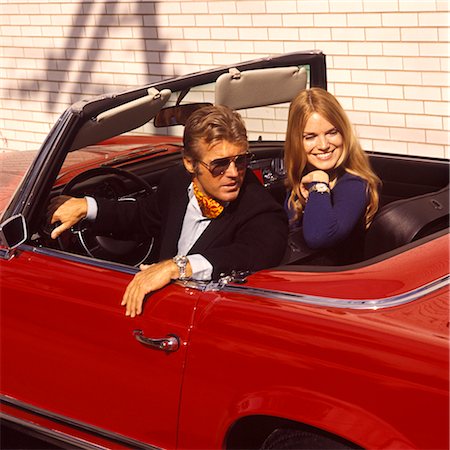 décapotable - ANNÉES 1970 HOMME FEMME COUPLE MODE ASSIS LES VOITURES ROUGES DE STYLE FASHION CONVERTIBLE CARTE SPORTS AUTOMOBILE AUTO AUTOS Photographie de stock - Rights-Managed, Code: 846-02794824