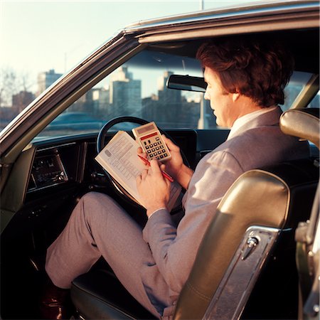 1970s MAN BUSINESSMAN SALESMAN USING POCKET CALCULATOR SITTING IN AUTOMOBILE Foto de stock - Con derechos protegidos, Código: 846-02794826