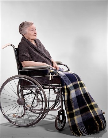 ANNÉES 1960 SAD HAUTS FEMME ASSISE EN FAUTEUIL ROULANT CHÂLE SUR LES ÉPAULES ET UNE COUVERTURE PLAID LAP Photographie de stock - Rights-Managed, Code: 846-02794868