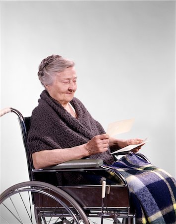 simsearch:846-02794863,k - 1960s SMILING SENIOR WOMAN SITTING IN WHEELCHAIR READING LETTER Foto de stock - Con derechos protegidos, Código: 846-02794869