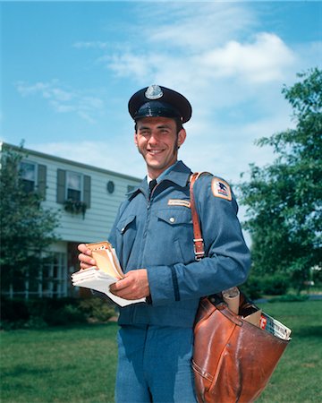 1970s 1980s SMILING MAILMAN MAIL MAN OUTDOORS HOLDING LETTERS SHOULDER BAG POSTAL SERVICE MEN WORKERS UNIFORM Stock Photo - Rights-Managed, Code: 846-02795004