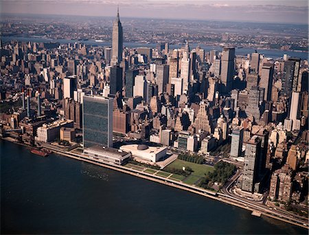 simsearch:846-03165463,k - 1970s AERIAL VIEW MIDTOWN MANHATTAN LOOKING WEST FROM ABOVE EAST RIVER TO UNITED NATIONS EMPIRE STATE BUILDING Fotografie stock - Rights-Managed, Codice: 846-02795057