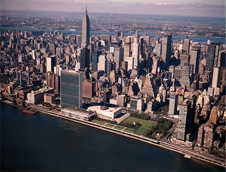 simsearch:846-02796344,k - 1970s AERIAL VIEW MIDTOWN MANHATTAN LOOKING WEST FROM ABOVE EAST RIVER TO UNITED NATIONS EMPIRE STATE BUILDING Stock Photo - Rights-Managed, Code: 846-02795057