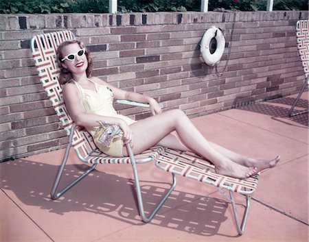 1950ER JAHRE LÄCHELNDE FRAU TRAGEN SONNENBRILLEN SONNE BADEN IM LIEGESTUHL LIEGE Stockbilder - Lizenzpflichtiges, Bildnummer: 846-02795158