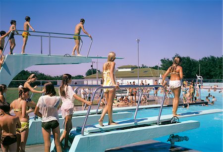 simsearch:846-03165804,k - 1970s CROWD OF TEENS IN POOL & ON DIVING BOARD AT MUNICIPAL SWIM POOL MCPHERSON KANSAS SUMMER FUN RECREATION COOL WET Foto de stock - Con derechos protegidos, Código: 846-02795183