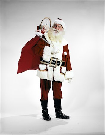 retro santa - 1960s FULL LENGTH PORTRAIT OF SANTA CLAUS WITH STUFFED TOY SACK ON HIS BACK STUDIO Foto de stock - Con derechos protegidos, Código: 846-02795289