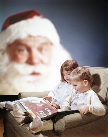 1970s BOY GIRL SITTING IN CHAIR READING A BOOK TOGETHER AS BACKGROUND SANTA FACE WATCHES Stock Photo - Rights-Managed, Code: 846-02795305