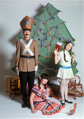 STUDIO SETTING OF FAMILY DRESSED AS CHRISTMAS CHARACTERS NUTCRACKERS DOLLS CHRISTMAS TREE IN BACKGROUND Stock Photo - Rights-Managed, Code: 846-02795325
