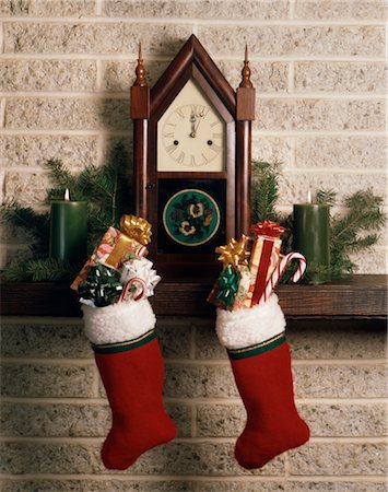1970s ANTIQUE CLOCK FIREPLACE MANTLE CHRISTMAS STOCKINGS FULL PRESENTS CANDY CANES Foto de stock - Con derechos protegidos, Código: 846-02795343