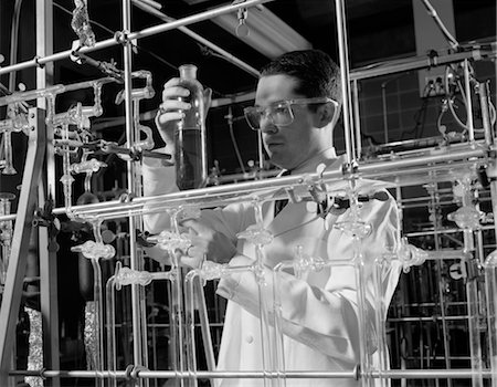 1960s MAN IN LAB COAT & GOGGLES SURROUNDED BY GLASS TUBING CONDUCTING SCIENTIFIC RESEARCH Stock Photo - Rights-Managed, Code: 846-02795367