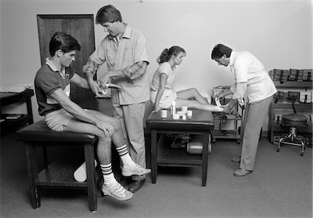 slogatura - 1980s MEDICAL OFFICE TEEN BOY HAVING WRIST BANDAGED & TEEN GIRL HAVING ANKLE BANDAGED Fotografie stock - Rights-Managed, Codice: 846-02795395