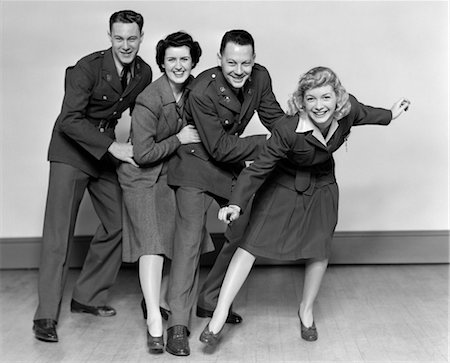 1940s CONGA LINE TWO MEN SOLDIERS AND TWO WOMEN DANCING SMILING LOOKING AT CAMERA Foto de stock - Con derechos protegidos, Código: 846-02795415