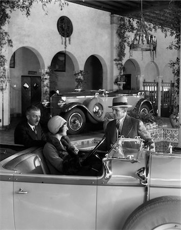 simsearch:846-02794841,k - 1920s WOMAN IN DRIVER'S SEAT OF CONVERTIBLE WITH HUSBAND & SALESMAN STANDING NEXT TO CAR IN FANCY SHOWROOM Foto de stock - Con derechos protegidos, Código: 846-02795452