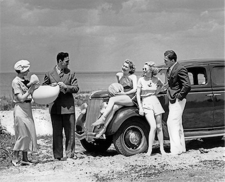 1930s GROUP OF FIVE MEN & WOMEN AT 1936 FORD V-8 PARKED ALONG SHORE PLAYING WITH INFLATABLE BEACH TOYS Stock Photo - Rights-Managed, Code: 846-02795520