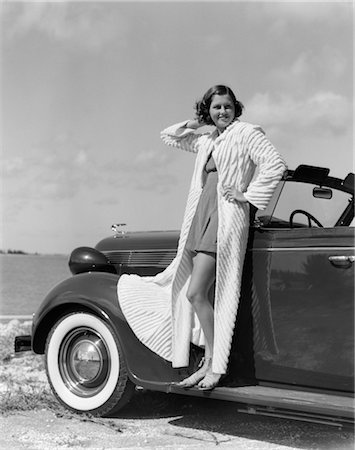 1930s 1940s SMILING WOMAN WEARING CHENILLE BEACH ROBE POSING ON RUNNING BOARD OF CONVERTIBLE ROADSTER AUTOMOBILE Stock Photo - Rights-Managed, Code: 846-02795570