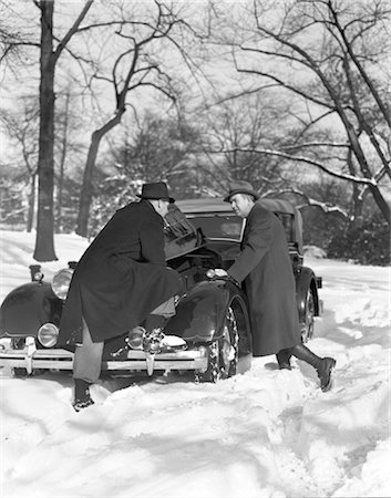 simsearch:846-02795516,k - 1930s TWO MEN LOOKING UNDER HOOD OF CAR WINTER SNOWY STREET BROKEN REPAIR COLD DISCUSSION CONSULTATION PROBLEM Foto de stock - Con derechos protegidos, Código: 846-02795580