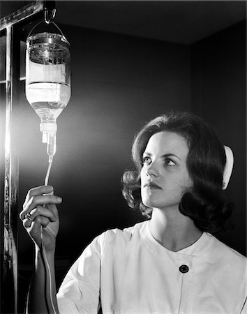 simsearch:846-02794841,k - 1960s WOMAN NURSE IN CAP AND UNIFORM IN EMERGENCY ROOM ADJUSTING FLOW FROM IV BOTTLE Foto de stock - Con derechos protegidos, Código: 846-02795614