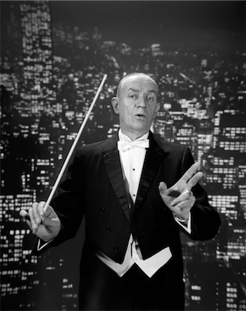 ORCHESTRA CONDUCTOR HOLD BATON TUXEDO TAILS CUTAWAY LEADING LEADER SYMPHONY CONTROL TEMPO BACKGROUND OF NIGHT CITY SKYLINE Stock Photo - Rights-Managed, Code: 846-02795634