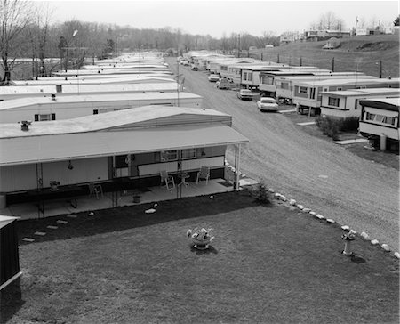 PARC À ROULOTTES DES ANNÉES 1970 AVEC DES RANGÉES DE MAISONS MOBILES DE CHAQUE CÔTÉ DE LA ROUTE EN GRAVIER Photographie de stock - Rights-Managed, Code: 846-02795646