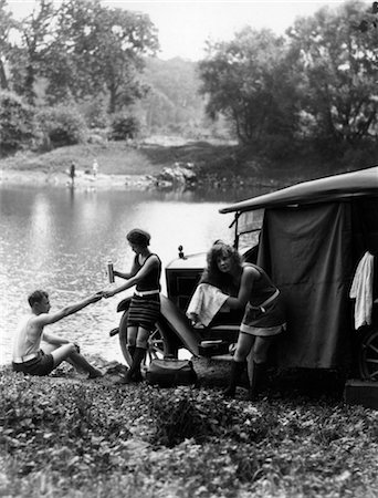 1920s GROUP OF TWO WOMEN AND ONE MAN AT LAKE WITH TOURING CAR TOWELING OFF HAIR AFTER SWIMMING Stock Photo - Rights-Managed, Code: 846-02795642