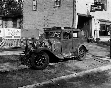 1920ER JAHREN ZERSTÖRTEN AUTO SITZEN AUF DEM BÜRGERSTEIG NEBEN MECHANIC'S SHOP Stockbilder - Lizenzpflichtiges, Bildnummer: 846-02795658