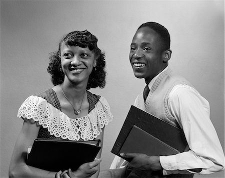 1950s TWO SMILING AFRICAN AMERICAN STUDENTS BOY GIRL CARRYING BOOKS COUPLE Stock Photo - Rights-Managed, Code: 846-02795734