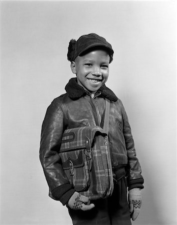 school jacket - 1940s 1950s AFRICAN AMERICAN BOY SMILING WEARING WINTER JACKET GLOVES HOLDING SCHOOL BOOK BAG Stock Photo - Rights-Managed, Code: 846-02795732