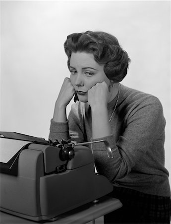 1960s DEPRESSED SECRETARY SITTING AT BUSINESS TYPEWRITER Stock Photo - Rights-Managed, Code: 846-02795786