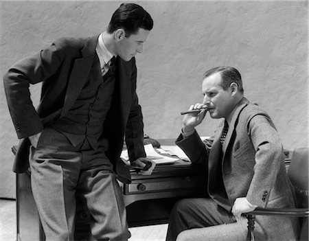 retro business man - 1930s TWO MEN AT DESK TALKING ONE MAN SMOKING CIGAR Stock Photo - Rights-Managed, Code: 846-02795798