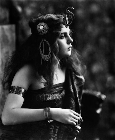 1910s 1920s WOMAN IN EGYPTIAN LOOKING COSTUME WEARING JEWELED ARM CUFF & ORNATE HEAD PIECE WITH SNAKE ON FRONT Foto de stock - Con derechos protegidos, Código: 846-02795875