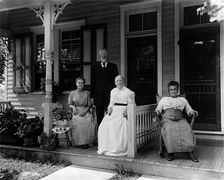 1890s 1900s TURN OF THE CENTURY GROUP OF FOUR NEIGHBORS SITTING ON THE PORCH OF A DUPLEX Foto de stock - Con derechos protegidos, Código: 846-02795886