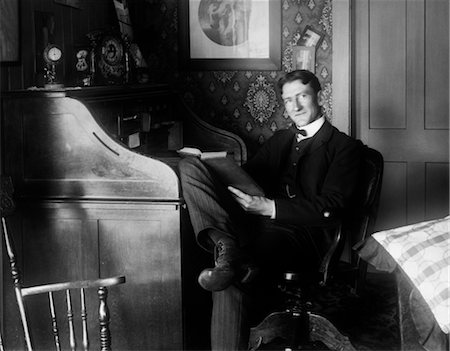 siglo 19 - 1890s 1900s TURN OF THE CENTURY MAN SITTING AT DESK READING BOOK Foto de stock - Con derechos protegidos, Código: 846-02795888