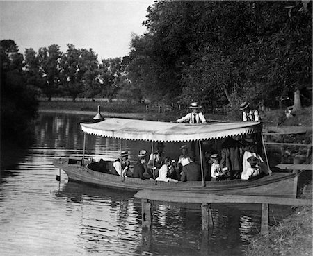 simsearch:846-02795924,k - 1890s 1900s TURN OF THE CENTURY GROUP IN BOAT WITH CANOPY BEING PUSHED OUT INTO LAKE Stock Photo - Rights-Managed, Code: 846-02795882