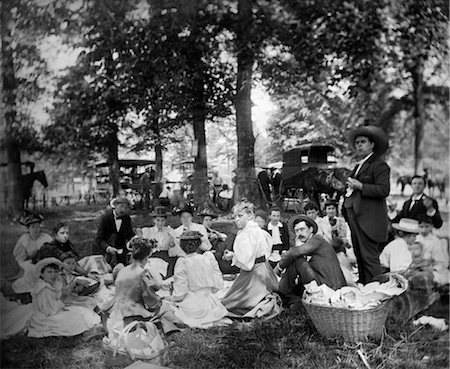 1890s 1900s TURN OF THE CENTURY GROUP HAVING PICNIC IN WOODS WITH HORSES & WAGONS IN BACKGROUND Foto de stock - Con derechos protegidos, Código: 846-02795890