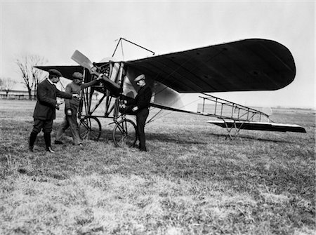 simsearch:846-02795924,k - 1910s GROUP OF THREE MEN STANDING IN FRONT OF EARLY MONOPLANE ONE WITH HAND ON PROPELLER Stock Photo - Rights-Managed, Code: 846-02795923