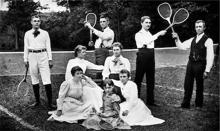 1890s TURN OF THE CENTURY GROUP PORTRAIT OF MEN HOLDING RACQUETS & WOMEN & ONE CHILD IN FRONT OF NET ON GRASS TENNIS COURT Foto de stock - Con derechos protegidos, Código: 846-02795958