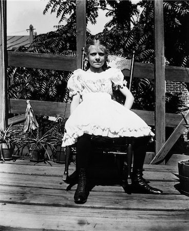 porch rocking chairs - 1890s 1900s TURN OF THE CENTURY GIRL IN WHITE DRESS SITTING ON ROCKING CHAIR ON PORCH Stock Photo - Rights-Managed, Code: 846-02795988