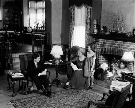 FAMILY 3 MOTHER FATHER CHILD GIRL MAN WOMAN LIVING ROOM FIREPLACE RUG LOUNGE RELAX TALK AFFLUENT 1920s UPSCALE RETRO VINTAGE Foto de stock - Con derechos protegidos, Código: 846-02796011