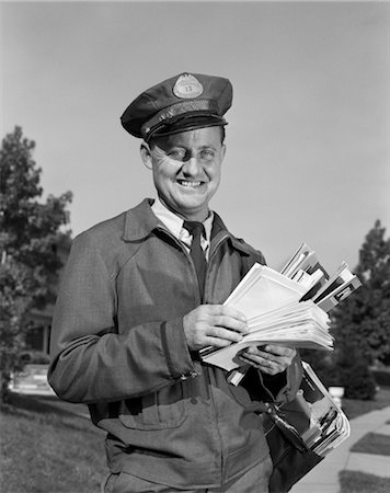 1960s SMILING MAILMAN OUTDOORS IN SUBURBAN NEIGHBORHOOD HOLDING LETTERS MAILBAG Stock Photo - Rights-Managed, Code: 846-02796215