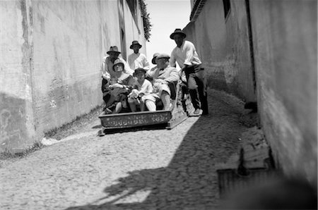 1920s 1930s MADEIRA ISLANDS TOURISTS SLIDING SLIDE DOWN HILL IN A FUNICULAR STEERED BY LOCAL GUIDES Stock Photo - Rights-Managed, Code: 846-02796248