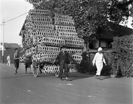 simsearch:846-02796405,k - ANNÉES 1930 ANNÉES 1920 HOMME TIRANT CHARIOT EMPILÉS HAUT AVEC PANIERS EN OSIER Photographie de stock - Rights-Managed, Code: 846-02796267