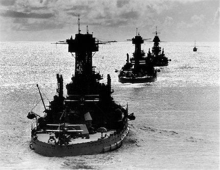 seconda guerra mondiale - 1940s LINE OF THREE USN BATTLESHIPS IN OCEAN STERN VIEW Fotografie stock - Rights-Managed, Codice: 846-02796261