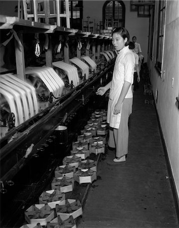 1920s 1930s CHINESE WOMAN SILK FACTORY WORKER AT WINDING MACHINES SPOOLS OF SILK TEXTILE THREAD Stock Photo - Rights-Managed, Code: 846-02796298