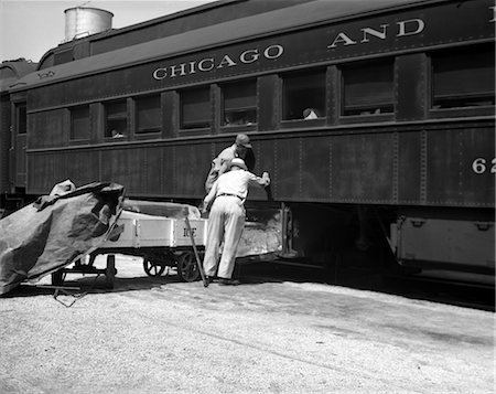 railway worker - 1930s 1940s TWO RAILROAD WORKERS PUTTING CAKES OF ICE INTO CLIMATE CONTROL AIR CONDITIONING COMPARTMENTS OF PASSENGER RAILROAD TRAIN Stock Photo - Rights-Managed, Code: 846-02796307