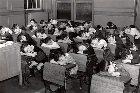 1930s ELEMENTARY GRADE SCHOOL STUDENTS CHILDREN SLEEPING WITH HEADS RESTING ON THEIR DESKS Stock Photo - Rights-Managed, Code: 846-02796340