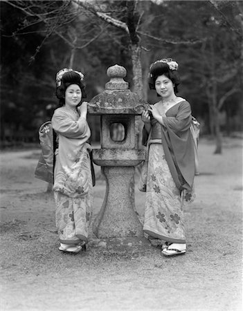 ANNÉES 1930 DEUX FILLES DE GEISHA JAPONAISE NATIVE COSTUME KIMONO PERMANENT DE LANTERNE GRANIT KOBE JAPON Photographie de stock - Rights-Managed, Code: 846-02796367