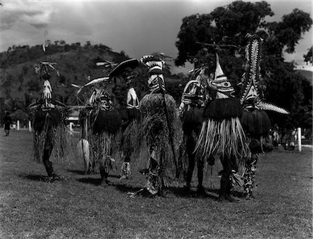 1920s 1930s GROUP OF NATIVES IN ELABORATE STRAW CEREMONIAL COSTUMES DEVIL CHASERS PORT MORESBY NEW GUINEA Foto de stock - Direito Controlado, Número: 846-02796384