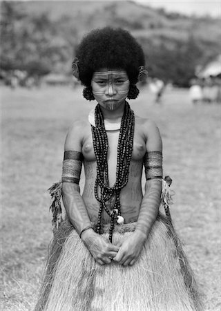 simsearch:846-02796389,k - 1920s 1930s NATIVE WOMAN TOPLESS NATIVE COSTUME GRASS SKIRT TATTOOS NECKLACE HANUABADA VILLAGE PORT MORESBY NEW GUINEA Foto de stock - Con derechos protegidos, Código: 846-02796385