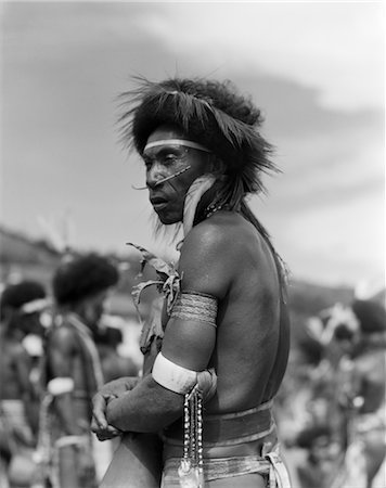 1920s 1930s PORTRAIT NATIVE PAPUAN WARRIOR PIERCED NOSE ARMBANDS HEAD DRESS PORT MORESBY NEW GUINEA Foto de stock - Direito Controlado, Número: 846-02796388