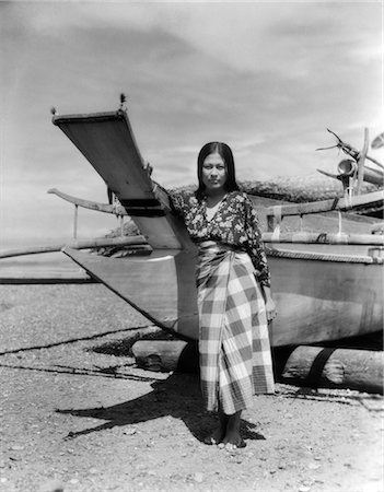 1930s 1940s A MORO GIRL NATIVE COSTUME STANDING BY CATAMARAN ON BEACH IN ZAMBOANGA Foto de stock - Con derechos protegidos, Código: 846-02796380